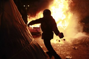 A pro-European protester throws a missile during clashes with Ukranian riot police in Kiev